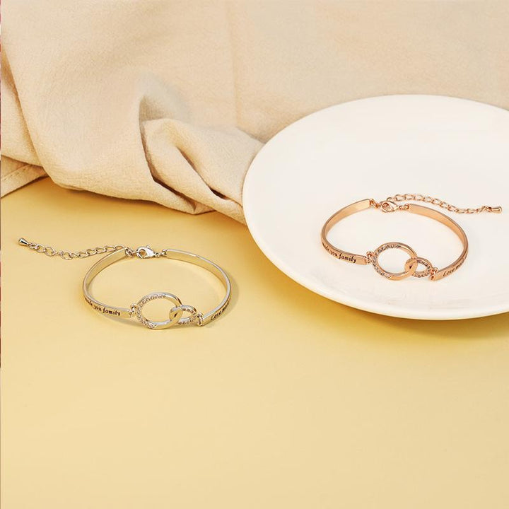 "Justerbart silver och rosguld vänskapsarmband för kvinnor med strass och graverad symbolik, elegant design."