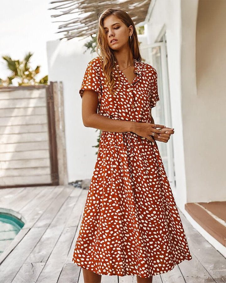 Knälång A-linje damklänning i mjuka toner med knappdetaljer, korta ärmar för sommarstil. Perfekt för avslappnad elegans.