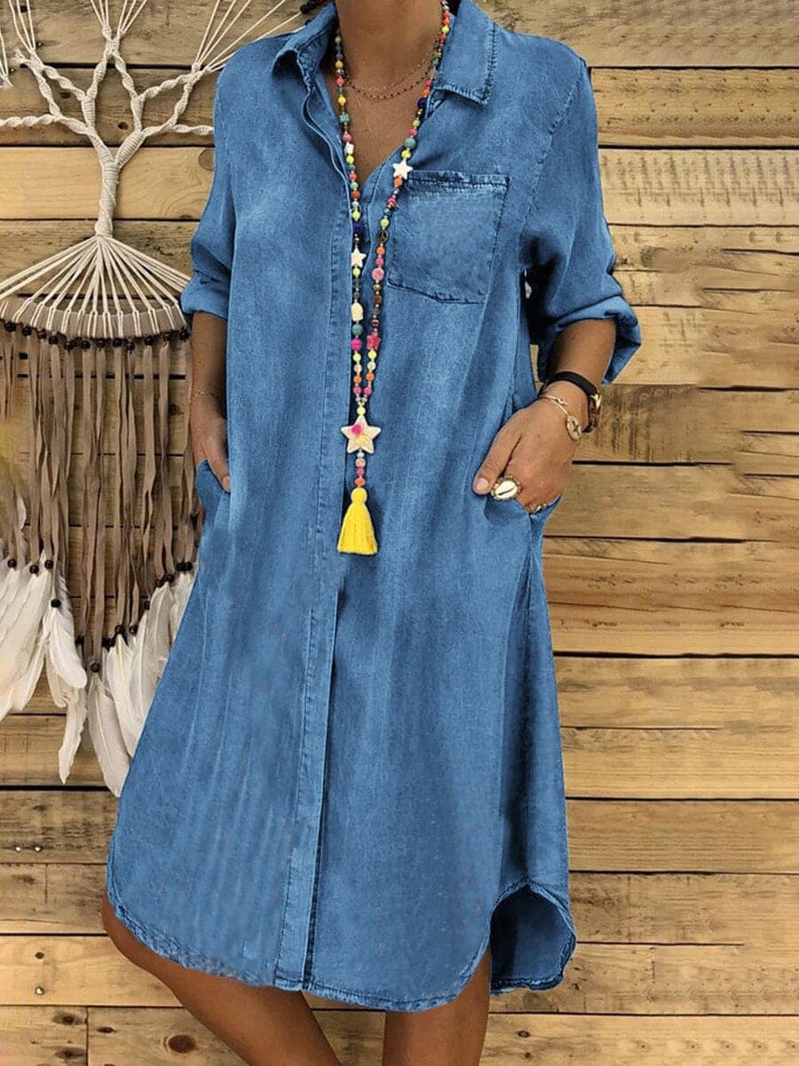 "Knälång denim skjortklänning med lång ärm, asymmetrisk fåll och bröstficka, perfekt för avslappnad stil."
