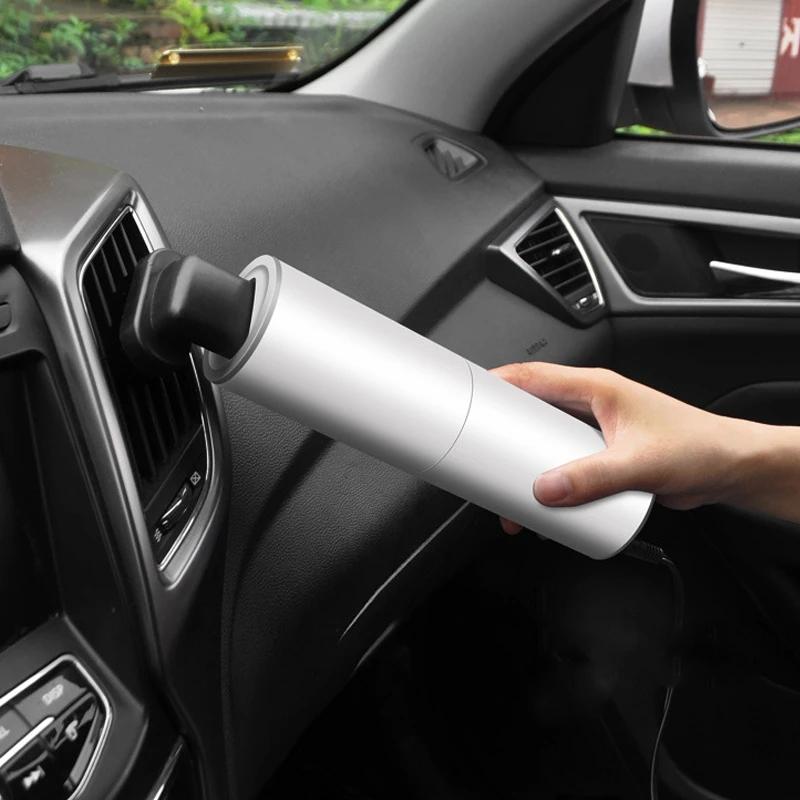 "Kompakt bärbar handdammsugare med kraftig sugning, perfekt för bilinteriörstädning. Svart design med mångsidiga munstycken."