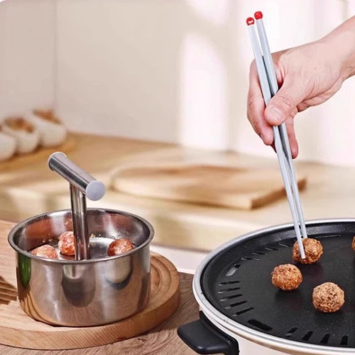 "Köttbullsformare i rostfritt stål, med elegant design, visar köttbullar formade snabbt och enkelt. Perfekt för köksentusiast