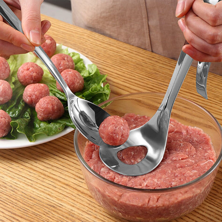 "Köttbullssked av rostfritt stål, silverfärgad, med ergonomiskt handtag och håldesign, perfekt för köttbullsformning."