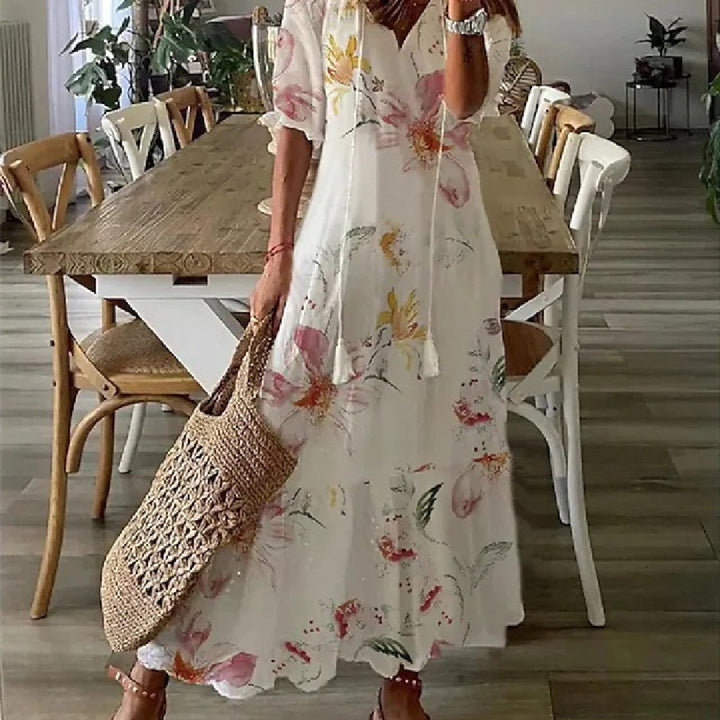 "Lång, blommig sommarklänning för dam med v-ringning och luftig design. Perfekt för semester och midsommar."