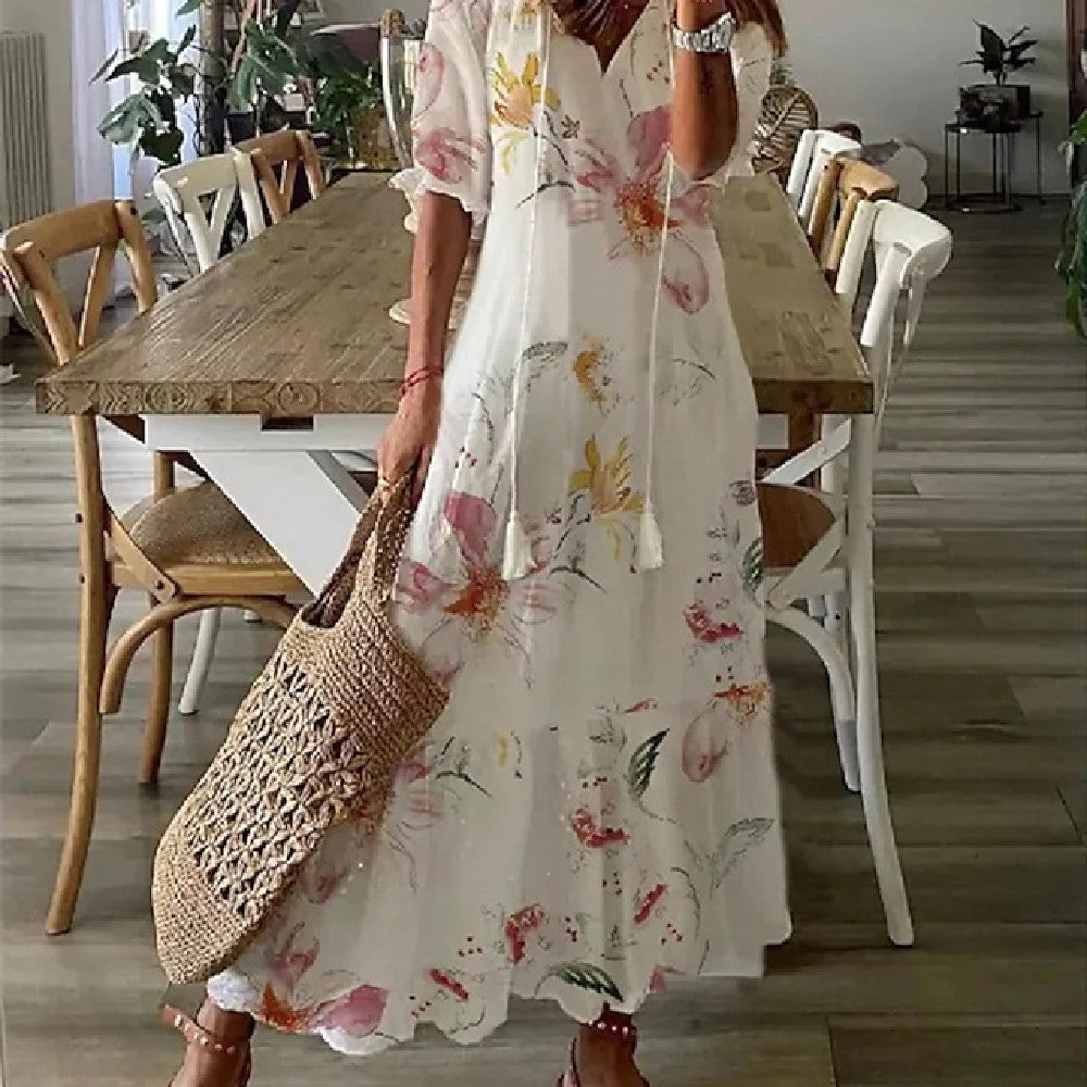 "Lång, blommig sommarklänning för dam med v-ringning och luftig design. Perfekt för semester och midsommar."