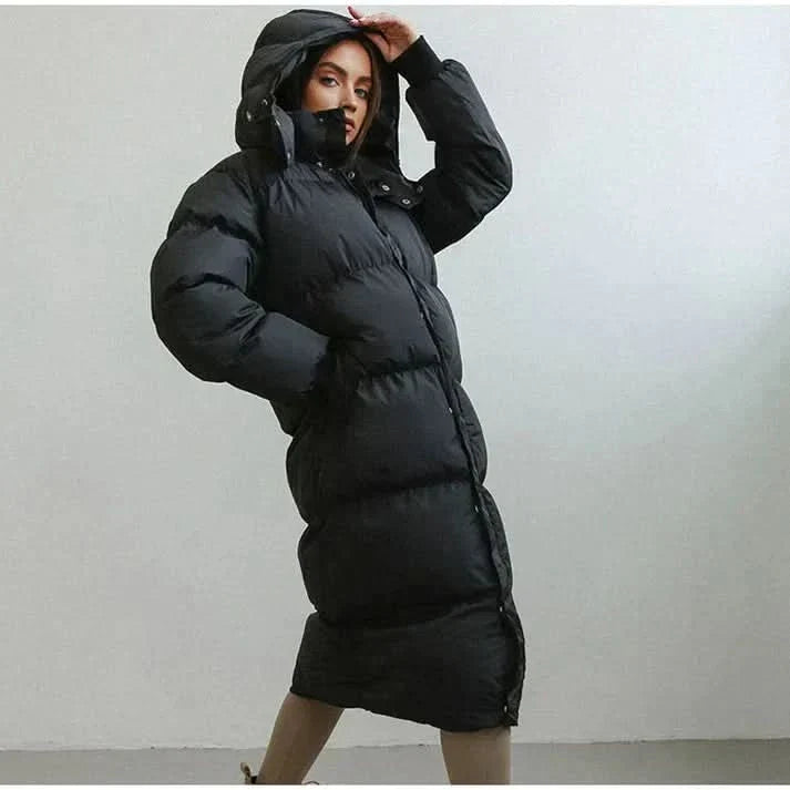 "Lång quiltad dunkappa dam med huva, oversized passform, varm vaddering, perfekt för vinterdagar och stilriktig komfort."