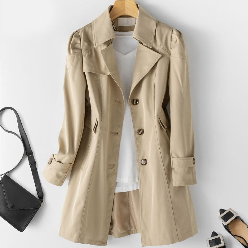 "Lätt och stilren kort trenchcoat i krämvitt med klassiska knappar och fickor, perfekt för sommaroutfits."