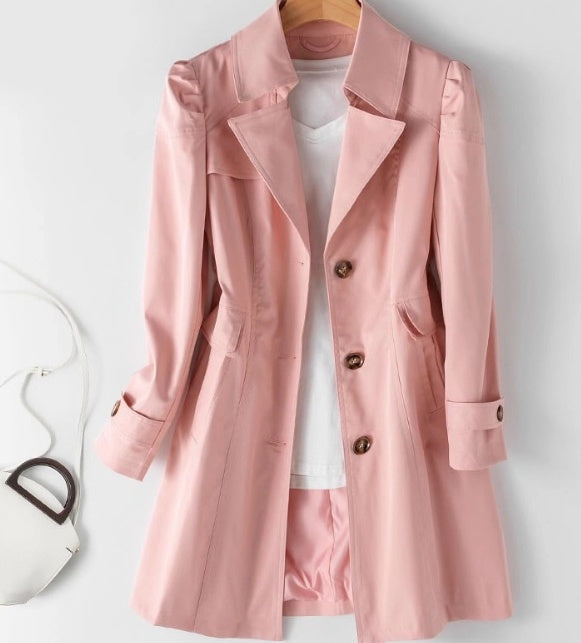 "Lätt och stilren kort trenchcoat i krämvitt med klassiska knappar och fickor, perfekt för sommaroutfits."