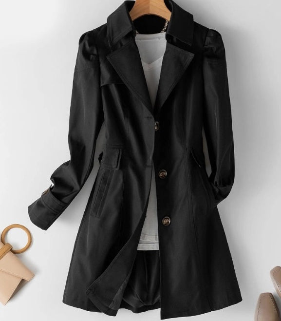 "Lätt och stilren kort trenchcoat i krämvitt med klassiska knappar och fickor, perfekt för sommaroutfits."