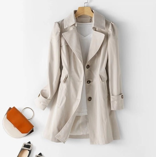 "Lätt och stilren kort trenchcoat i krämvitt med klassiska knappar och fickor, perfekt för sommaroutfits."
