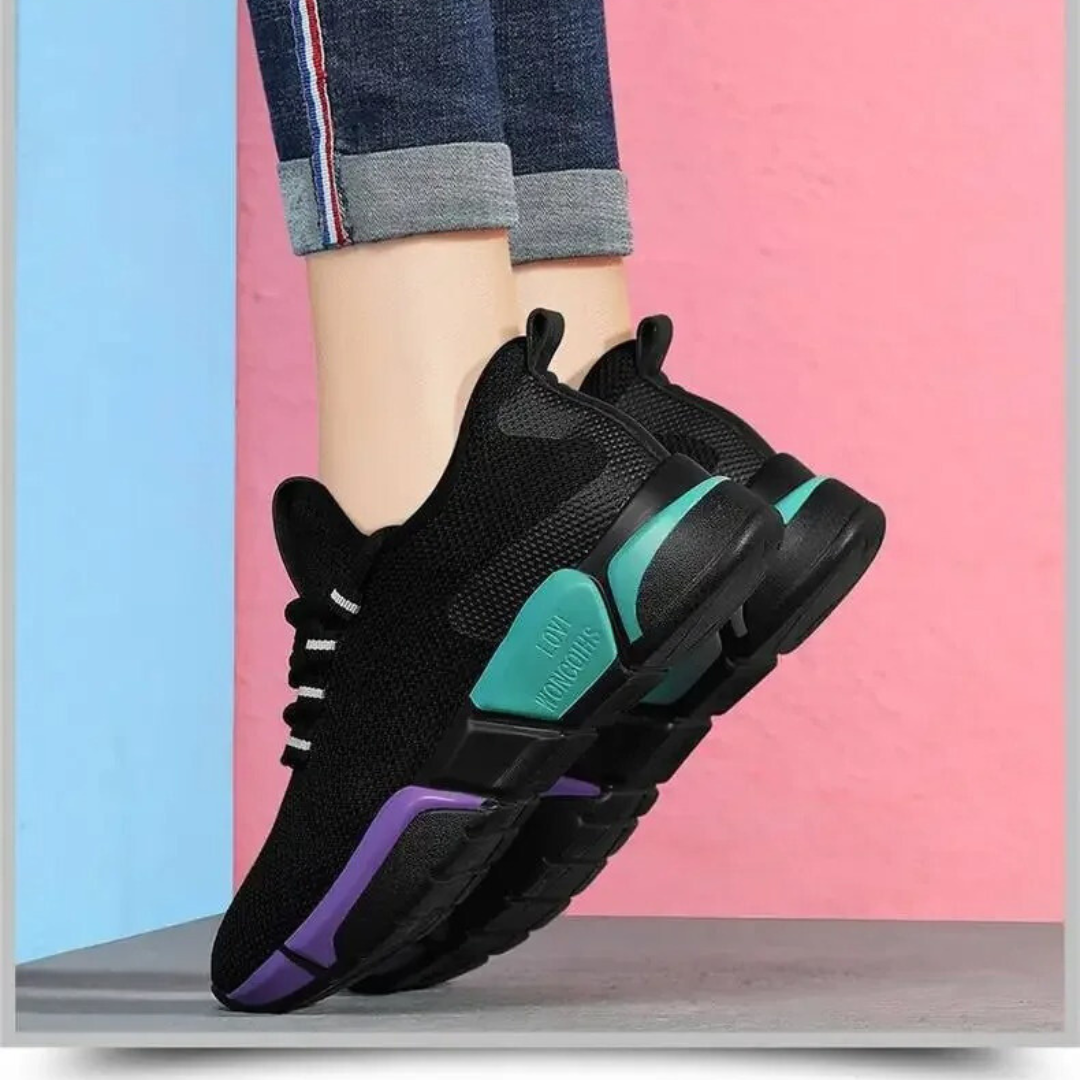 "Lättviktiga damsneakers i lila, rött, svart och vitt med andningsbart meshmaterial och flexibel, halkfri sula."