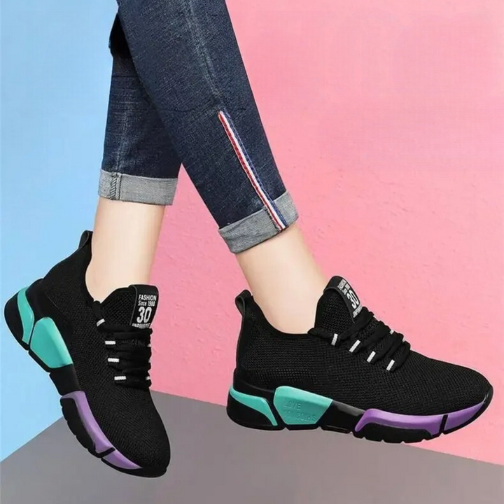 "Lättviktiga damsneakers i lila, rött, svart och vitt med andningsbart meshmaterial och flexibel, halkfri sula."