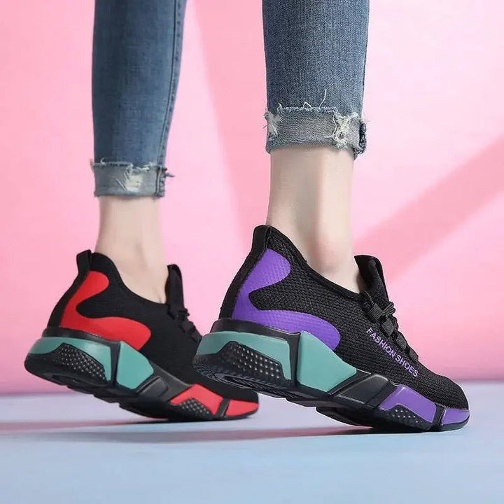 "Lättviktiga damsneakers i lila, rött, svart och vitt med andningsbart meshmaterial och flexibel, halkfri sula."