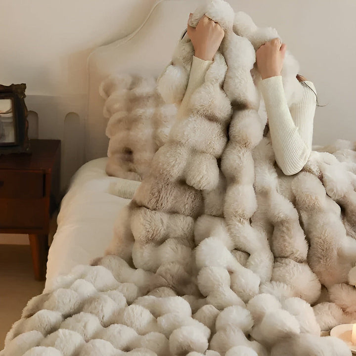 "Lyxig fuskpäls värmefilt, mjuk och elegant, perfekt för mysigt hem och resor, beige ton med stilren design."