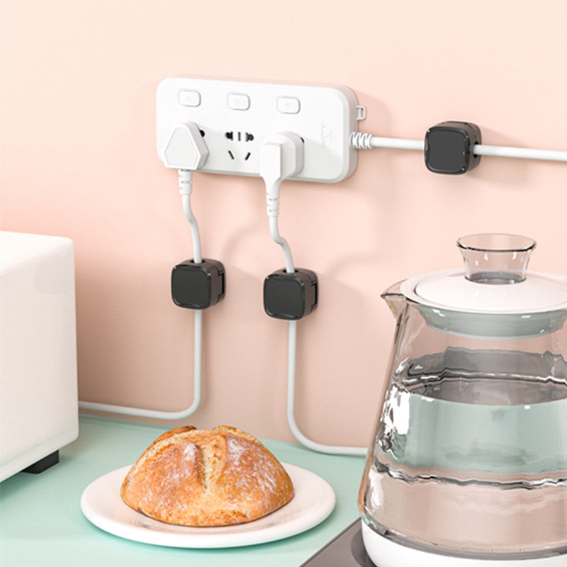 "Magnetisk kabelhållare håller kablar organiserade, stilren design i svart och vit, passar kablar upp till 7 mm."