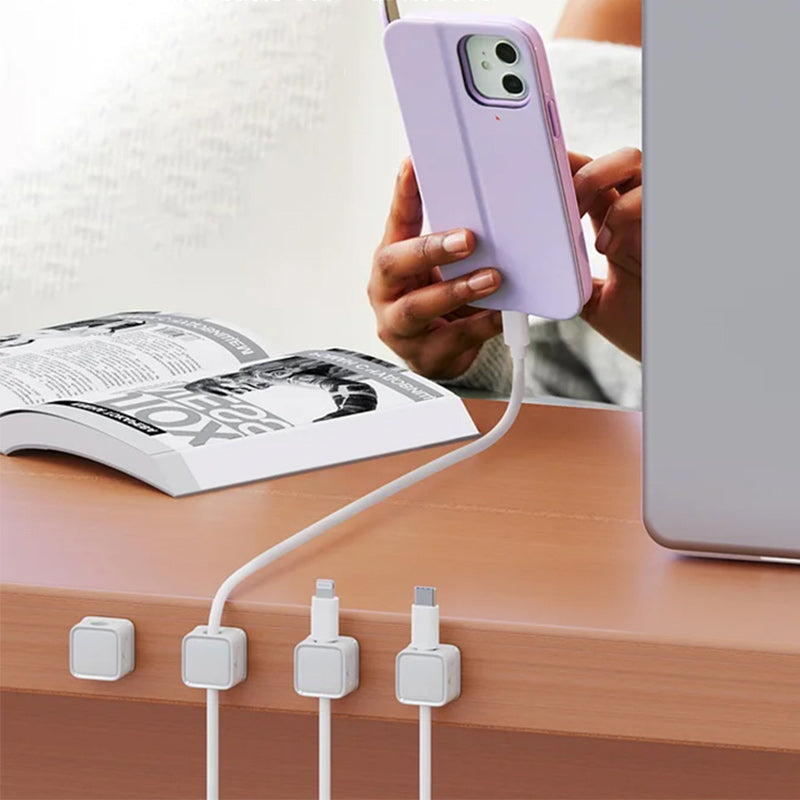 "Magnetisk kabelhållare håller kablar organiserade, stilren design i svart och vit, passar kablar upp till 7 mm."