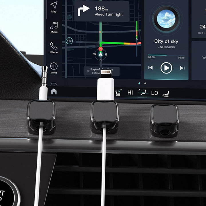 "Magnetisk kabelhållare håller kablar organiserade, stilren design i svart och vit, passar kablar upp till 7 mm."
