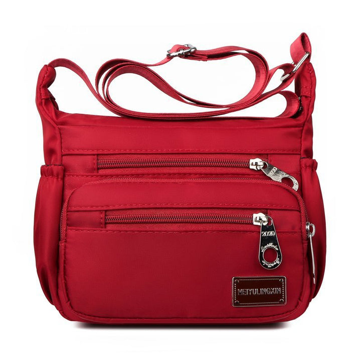 Mångsidig och slitstark axelremsväska i nylon för kvinnor, med justerbar rem och flera fickor, perfekt för vardag och resor.