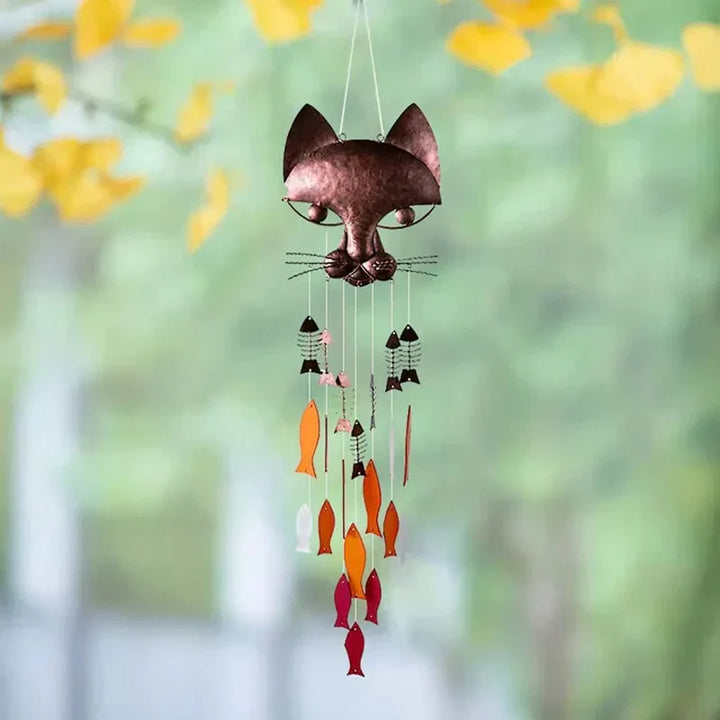 "Metallisk vindspel med katt och fiskdesign, detaljrikt konstverk för trädgård eller terrass. Vattentålig och elegant."