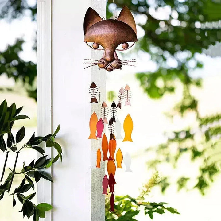 "Metallisk vindspel med katt och fiskdesign, detaljrikt konstverk för trädgård eller terrass. Vattentålig och elegant."