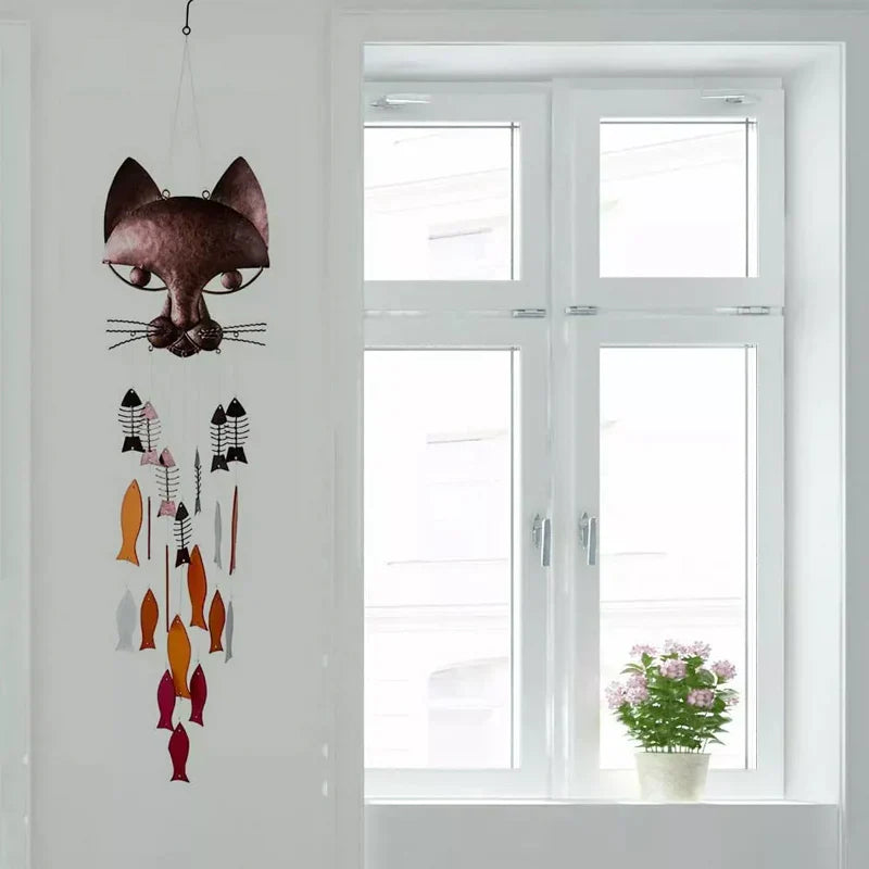 "Metallisk vindspel med katt och fiskdesign, detaljrikt konstverk för trädgård eller terrass. Vattentålig och elegant."