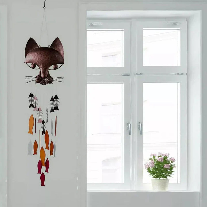 "Metallisk vindspel med katt och fiskdesign, detaljrikt konstverk för trädgård eller terrass. Vattentålig och elegant."