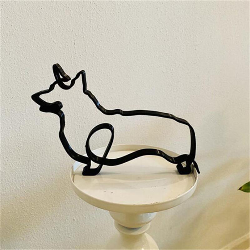 "Minimalistisk svart hunddekoration i metall som pryder väggen, perfekt för modern inredning och konstnärlig touch."