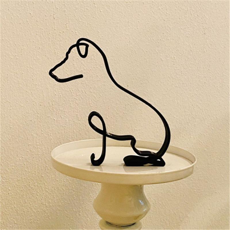 "Minimalistisk svart hunddekoration i metall som pryder väggen, perfekt för modern inredning och konstnärlig touch."