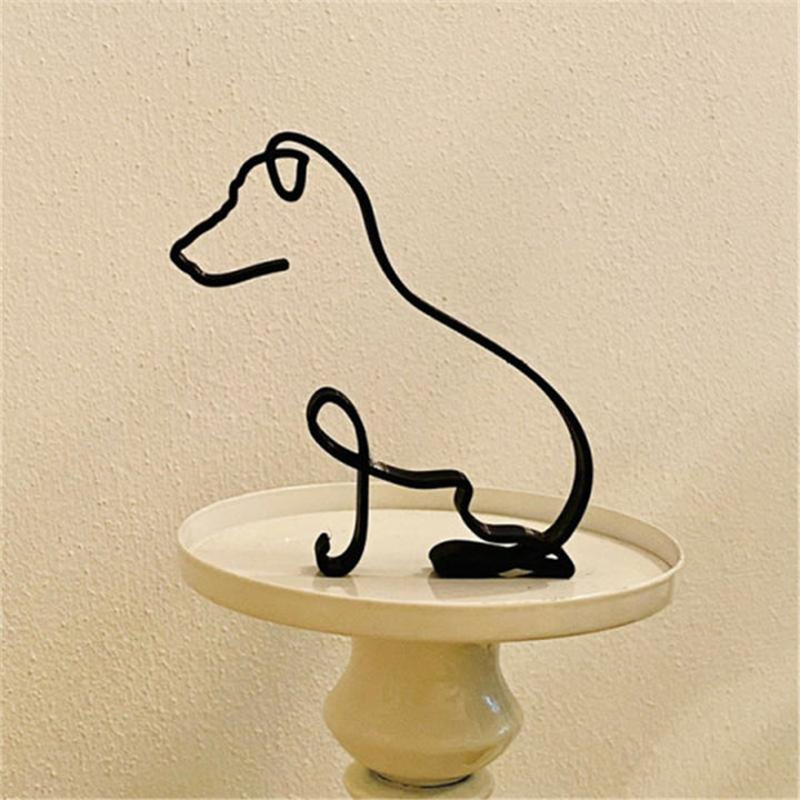 "Minimalistisk svart hunddekoration i metall som pryder väggen, perfekt för modern inredning och konstnärlig touch."