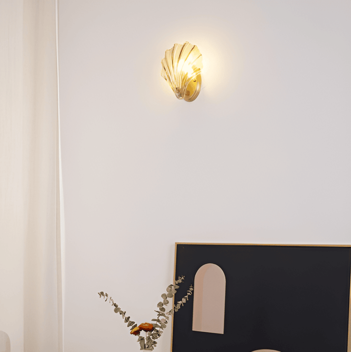 "Minimalistisk vägglampa med snäckskal och tryckknapp, eleganta mässings- och glasdetaljer, diameter 20 cm, höjd 22 cm."