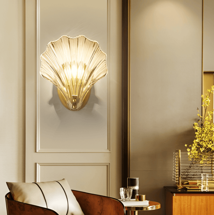 "Minimalistisk vägglampa med snäckskal och tryckknapp, eleganta mässings- och glasdetaljer, diameter 20 cm, höjd 22 cm."
