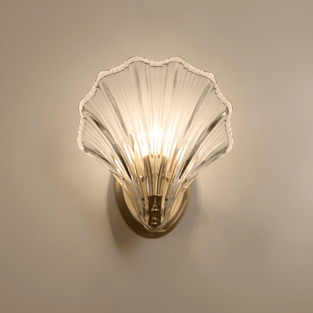 "Minimalistisk vägglampa med snäckskal och tryckknapp, eleganta mässings- och glasdetaljer, diameter 20 cm, höjd 22 cm."