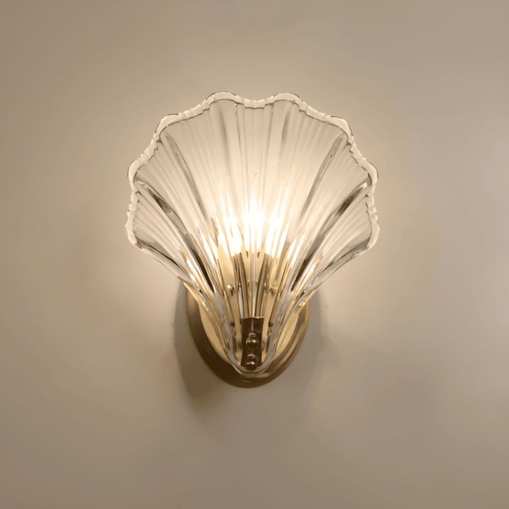 "Minimalistisk vägglampa med snäckskal och tryckknapp, eleganta mässings- och glasdetaljer, diameter 20 cm, höjd 22 cm."