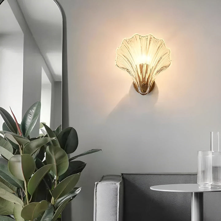 "Minimalistisk vägglampa med snäckskal och tryckknapp, eleganta mässings- och glasdetaljer, diameter 20 cm, höjd 22 cm."
