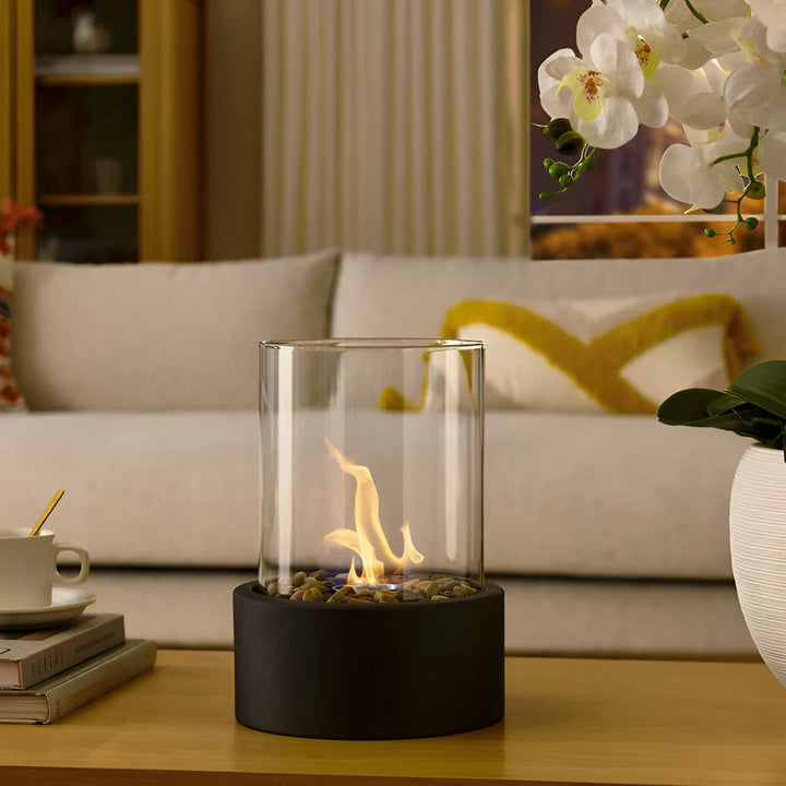 "Modern bordspis med svart metallbas och glascylinder, perfekt som inredningsdetalj för elegant och avkopplande atmosfär."