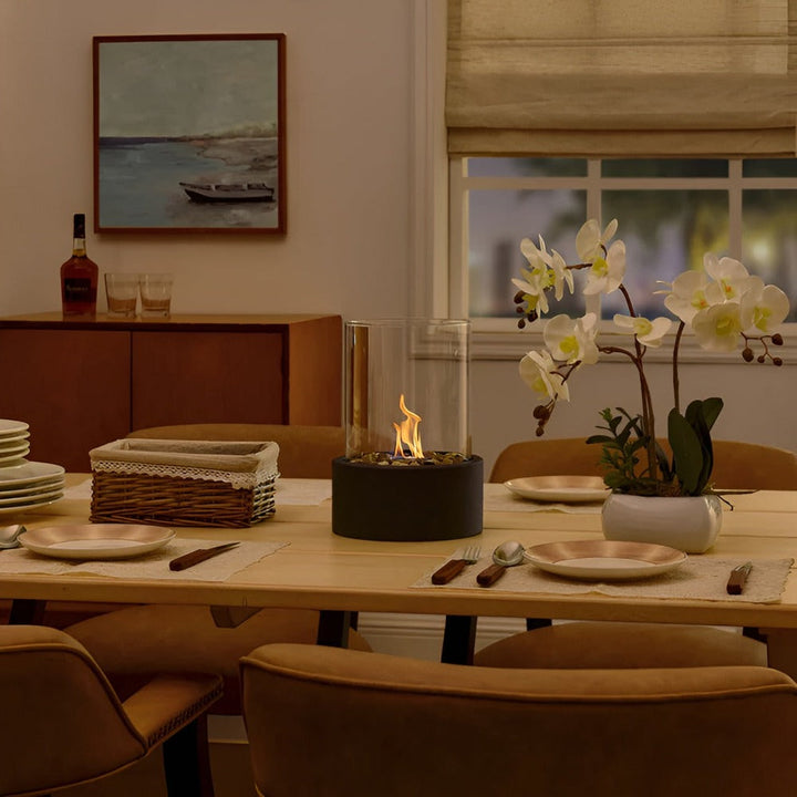 "Modern bordspis med svart metallbas och glascylinder, perfekt som inredningsdetalj för elegant och avkopplande atmosfär."