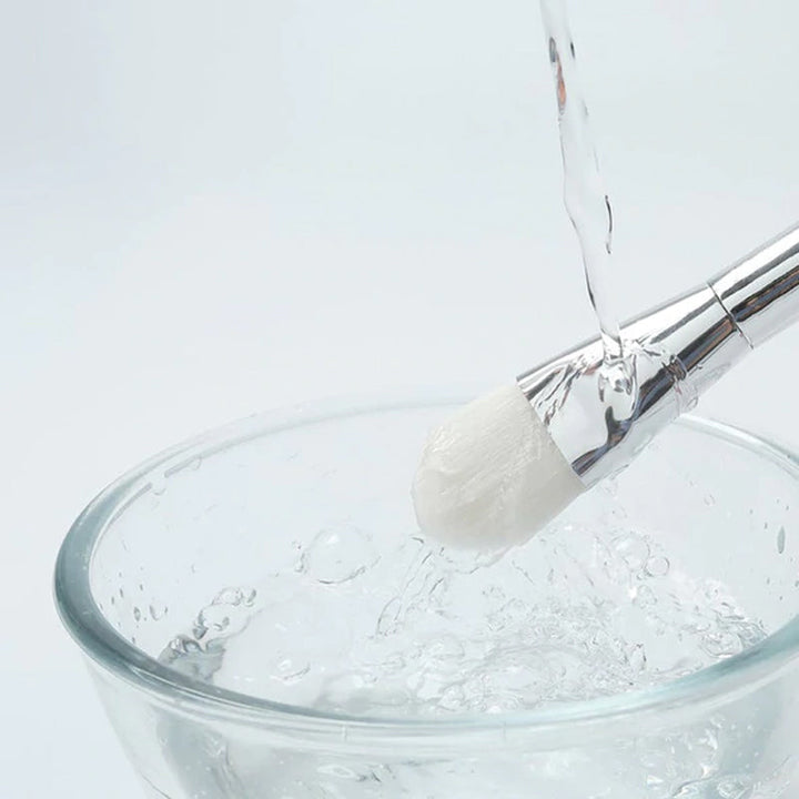 "Modern dispenserbehållare och maskborste i plast och silikon, perfekt för resor och daglig användning."