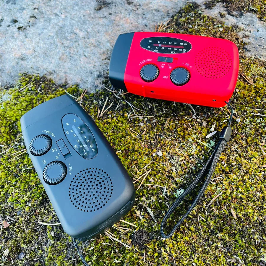 "Nödradio med solceller, ficklampa och USB-port, röd färg, kompakt design för utomhusbruk och nödsituationer."