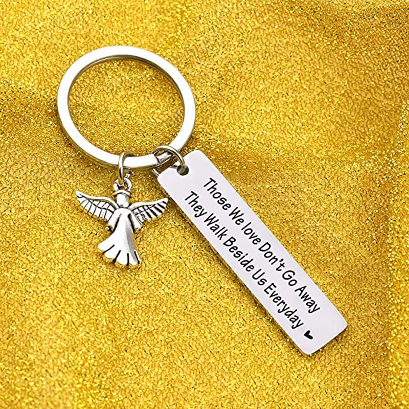 "Nyckelring med silverfärgade änglavingar och hjärta, spegelpolerat stål, elegant souvenir och minnesgåva."