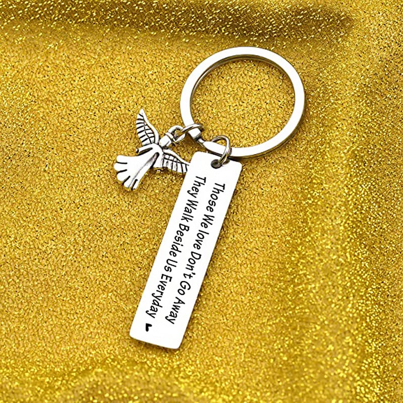 "Nyckelring med silverfärgade änglavingar och hjärta, spegelpolerat stål, elegant souvenir och minnesgåva."