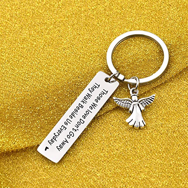 "Nyckelring med silverfärgade änglavingar och hjärta, spegelpolerat stål, elegant souvenir och minnesgåva."