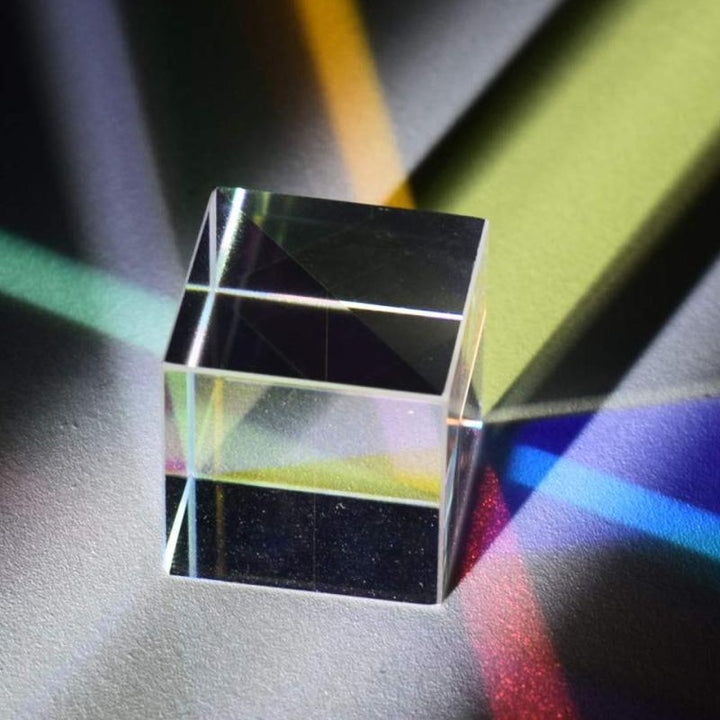 "Optisk prisma kub med färgspel, kompaktdesign, glaspaneler som skapar kalejdoskop av färger vid ljusbrytning."