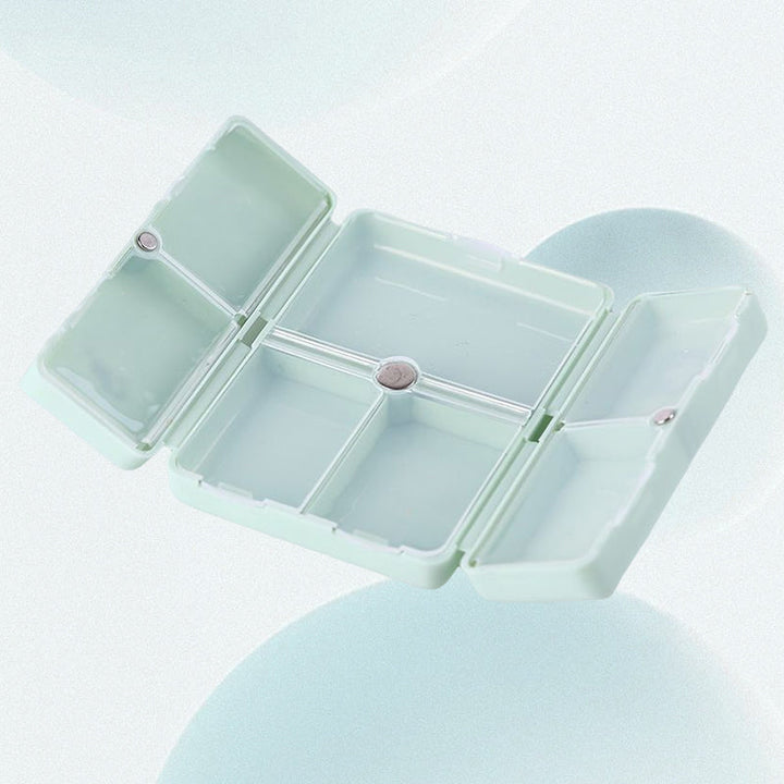 "Pillerfodral med 7 fack i olika färger, magnetisk stängning, kompakt för resor."