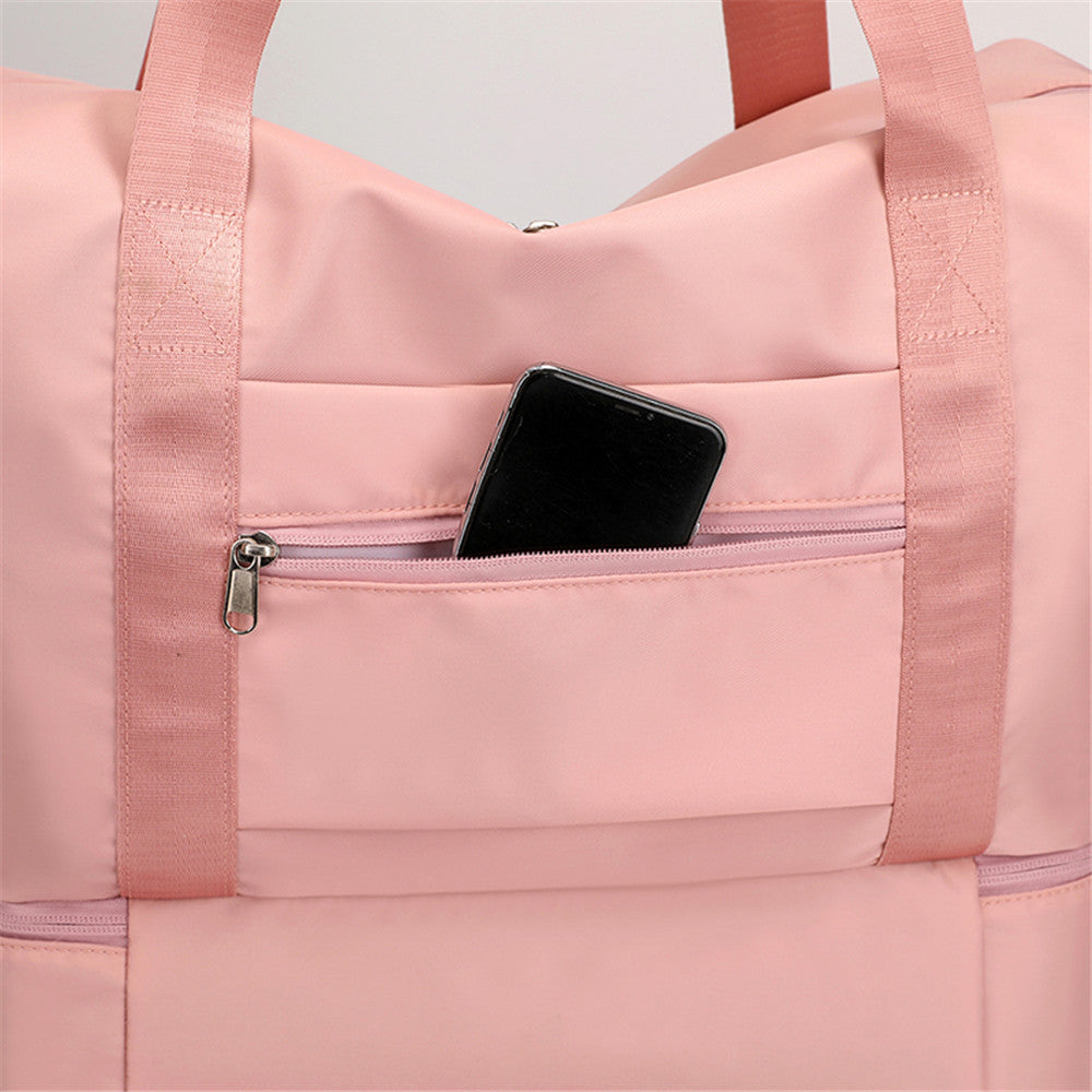 En sportig bild av den rosa Catalina Deluxe väskan med träningskläder inuti.