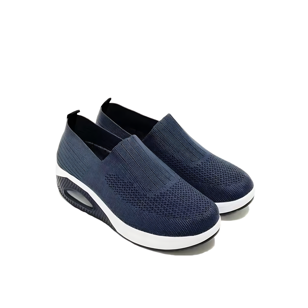 Kvinnofötter i rosa ergonomiska damsneakers på gräsmatta, framhäver fritidsskor och komfort.