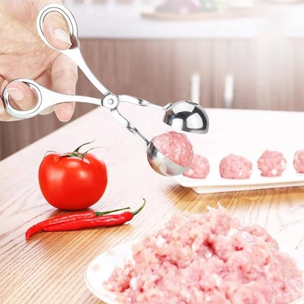 "Rostfri köttbulleskopa i silver, saxgrepp-design, idealisk för jämna köttbullar, meloner och kakbollar, i köksmiljö."