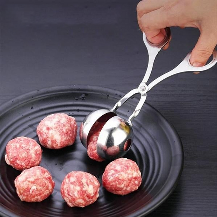 "Rostfri köttbulleskopa i silver, saxgrepp-design, idealisk för jämna köttbullar, meloner och kakbollar, i köksmiljö."