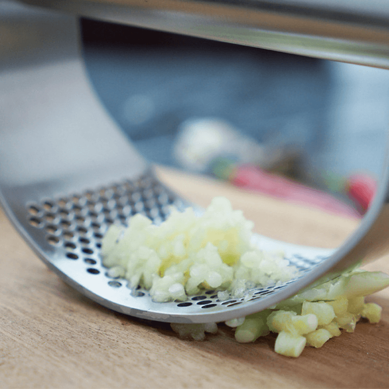 "Rostfri vitlökspress i ergonomisk design för enkel matlagning, krossar vitlök snabbt med stil och funktionalitet."