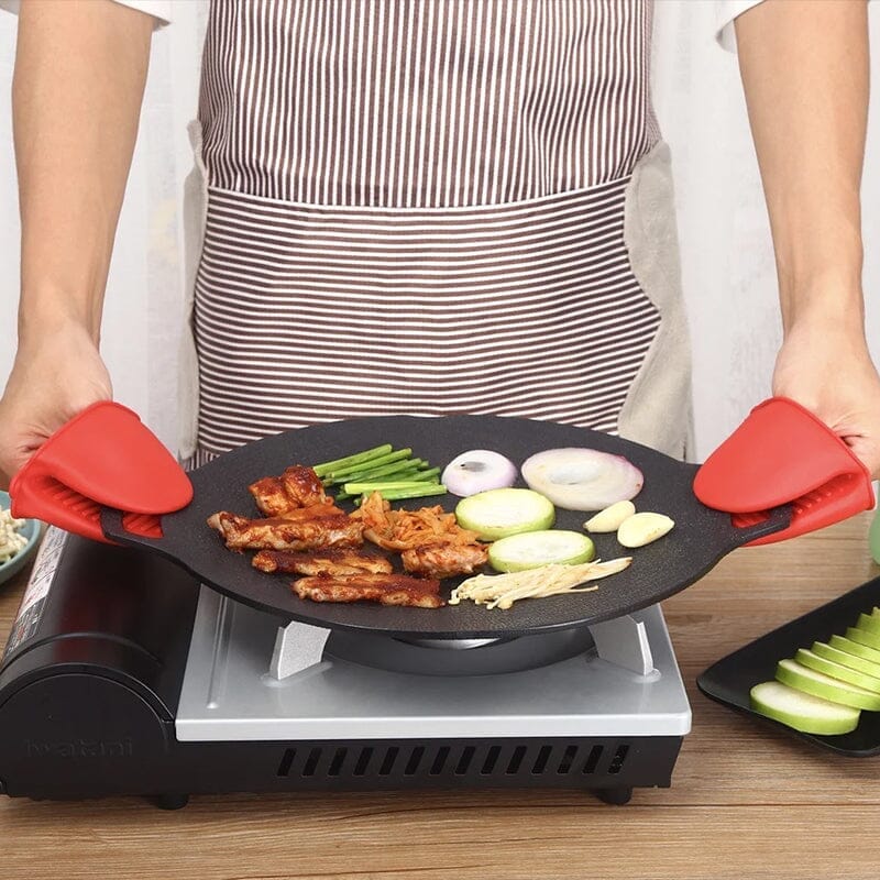 Rund non-stick stekpanna i svart aluminiumlegering med två öronhandtag, idealisk för grillmatlagning utomhus.