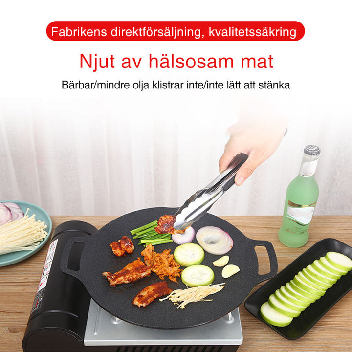 Rund non-stick stekpanna i svart aluminiumlegering med två öronhandtag, idealisk för grillmatlagning utomhus.