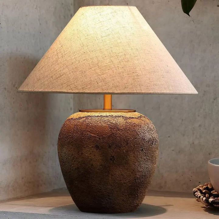 "Rustik bordslampa med keramikfot och krämfärgad linneskärm, tidlös stil för heminredning."